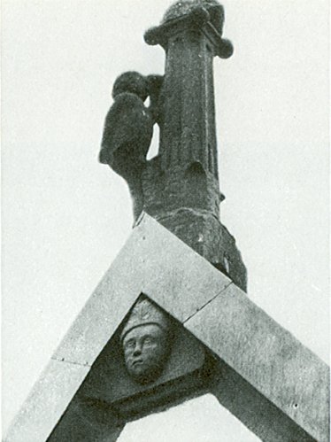 Mitte: Dachaufsatz auf dem Westgiebel mit kletterndem Männlein und Bischofskopf